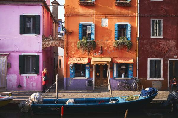 Colorful buildings with canal boats detail itinerary Venice walking vacation